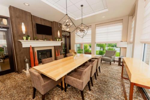 a dining room with a table and chairs and a fireplace at Hilton Garden Inn Indiana at IUP in Indiana