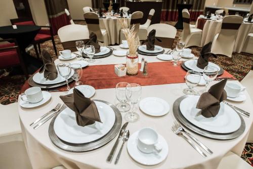 a white table with white plates and silverware on it at Hilton Garden Inn Indiana at IUP in Indiana