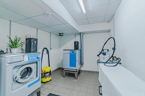a room with a washing machine in a hospital room at Montempô Apparthôtel Lyon Viviani in Vénissieux