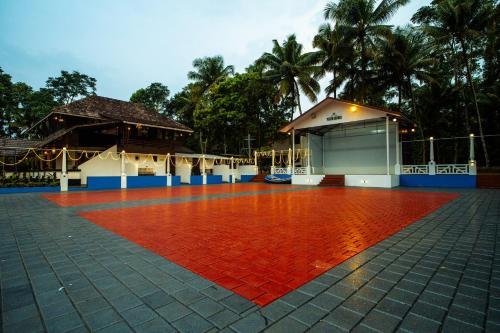 um piso de tijolos vermelhos em frente a um edifício em Arayathu Heritage Villa Resort em Kottayam