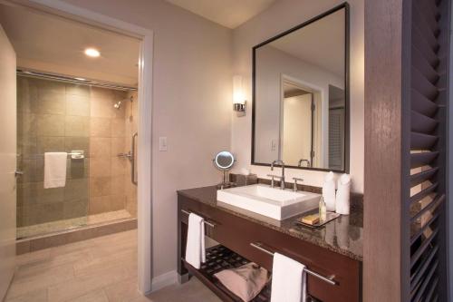 a bathroom with a sink and a mirror and a shower at DoubleTree Resort Hollywood Beach in Hollywood