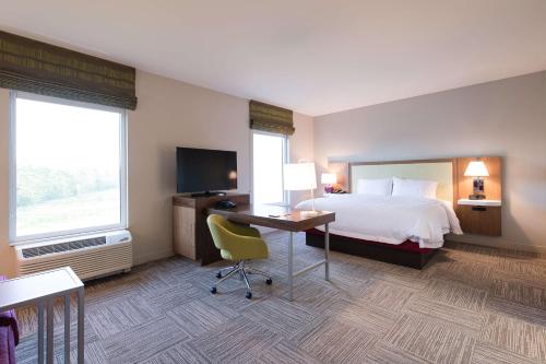 a hotel room with a bed and a desk with a computer at Hampton Inn and Suites Fayetteville, NC in Fayetteville