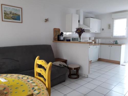 a living room with a couch and a kitchen at Villa quartier des Arros - 4428 in Soulac-sur-Mer
