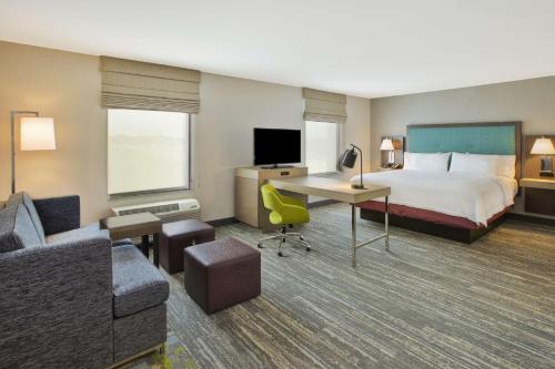 a hotel room with a bed and a desk at Hampton Inn & Suites By Hilton, Southwest Sioux Falls in Sioux Falls