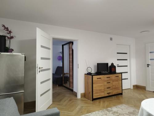 een woonkamer met een koelkast en een houten dressoir bij Piasecki Apartamenty in Lublin