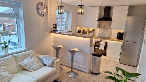 a living room with a couch and a kitchen at NEW 2 bedrooms with private ensuite bathrooms near Heathrow in Ashford