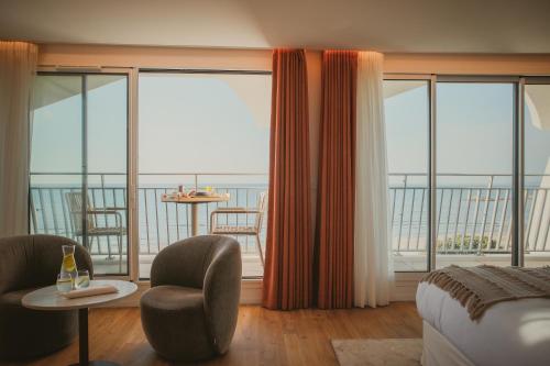 a hotel room with a bed and a large window at Hôtel La Plage 5 étoiles La Grande Motte in La Grande-Motte