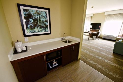 a kitchen with a sink and a living room at Hampton Inn By Hilton Kirksville MO in Kirksville