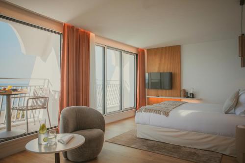 ラ・グランド・モットにあるHôtel La Plage 5 étoiles La Grande Motteのベッドとバルコニー付きのホテルルーム