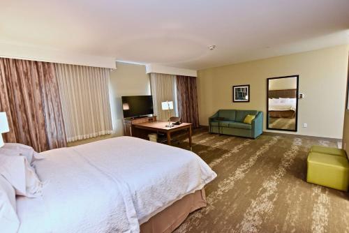 a hotel room with a large bed and a couch at Hampton Inn By Hilton Kirksville MO in Kirksville