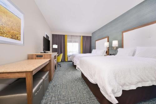 Cette chambre comprend 2 lits et une télévision à écran plat. dans l'établissement Hampton Inn Emporia, KS, à Emporia