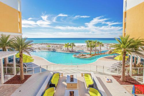 an aerial view of a resort with a pool and the ocean at Hilton Garden Inn Ft. Walton Beach in Fort Walton Beach