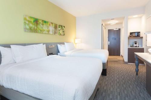a hotel room with two beds and a kitchen at Hilton Garden Inn Ft. Walton Beach in Fort Walton Beach