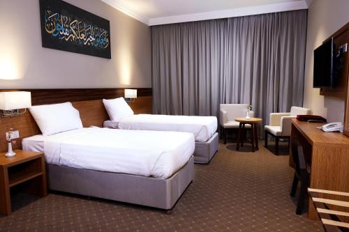 麥加的住宿－فنادق رزون المسك مكة المكرمة，酒店客房设有两张床和电视。