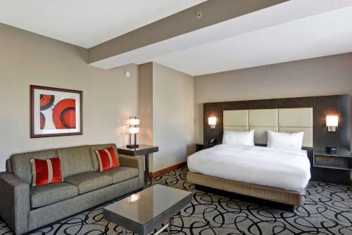 Habitación de hotel con cama y sofá en DoubleTree by Hilton Hattiesburg, MS, en Hattiesburg