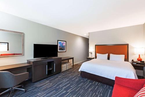 a hotel room with a bed and a flat screen tv at Hampton Inn & Suites Houston/Atascocita, Tx in Humble