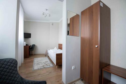 a room with a bedroom with a bed and a mirror at Hotel Polonia in Rzeszów