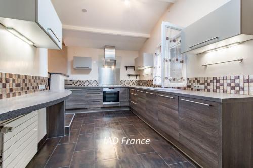une grande cuisine avec des placards en bois et une grande fenêtre dans l'établissement Victory Villa Vacations, à Chambourcy