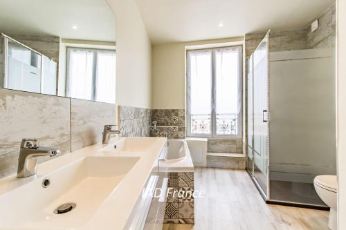 La salle de bains est pourvue d'un grand lavabo et de toilettes. dans l'établissement Victory Villa Vacations, à Chambourcy