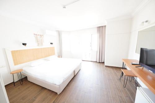 a white room with a bed and a television at Chillos Beach in Marmaris