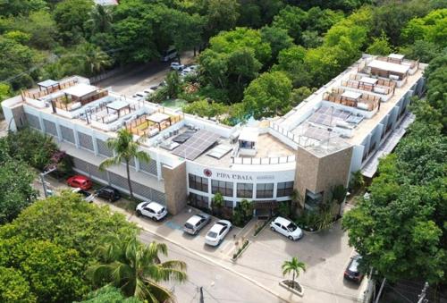 a large building with cars parked in front of it at Ubaia charme & conforto in Pipa