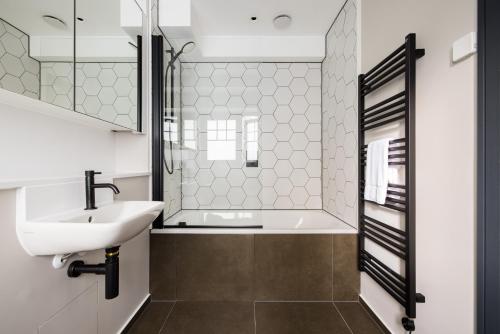 a bathroom with a sink and a bath tub at Covent Garden Apartments in London