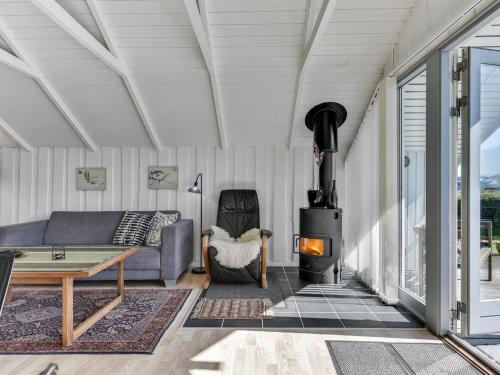 a living room with a couch and a wood stove at Holiday Home Katrina - 50m to the inlet in SE Jutland by Interhome in Broager