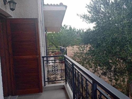 a balcony with a wooden door and a view of a beach at Villa Margarita in Chalkida