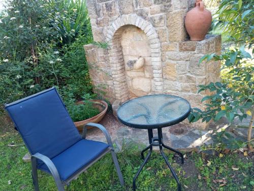 a table and a chair and a table and a stool at Villa Margarita in Chalkida