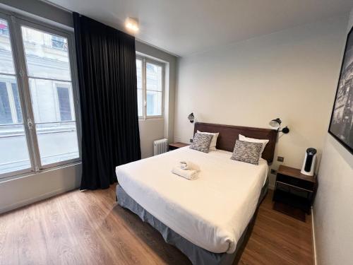um quarto com uma cama e uma grande janela em 78 - Urban Beautiful Le Marais em Paris