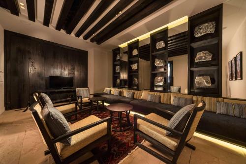 a living room with a couch and chairs and a television at Alila Jabal Akhdar in Al Khuţaym