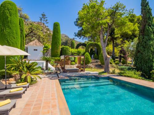 a swimming pool in a garden with trees and a gazebo at Cubo's Mountain Bayview Luxury Villa in Málaga