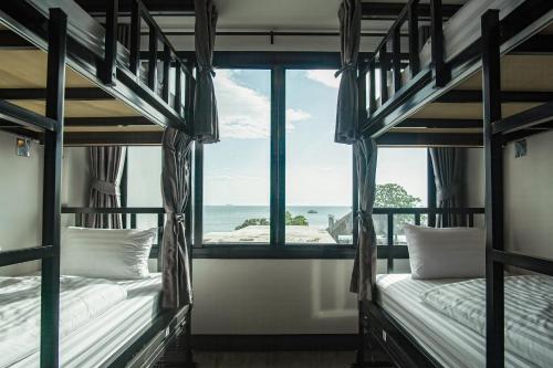 two bunk beds in a room with a view of the ocean at Sea Beach Hostel & Club AoNang Beachfront in Ao Nang Beach