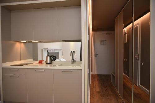 a kitchen with white cabinets and a sink at Premium apartments - the star of Batumi Palace in Batumi