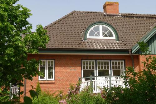 a red brick house with a window and a white fence at Seedüne in Wyk auf Föhr