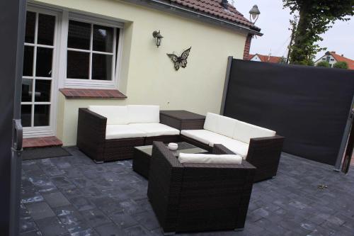 een patio met twee banken en een vlinder op een huis bij Hafenperle Carolinensiel in Carolinensiel