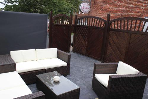 een patio met rieten stoelen, een tafel en een hek bij Hafenperle Carolinensiel in Carolinensiel