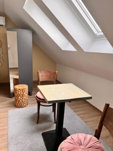 a table and chairs in a room with a skylight at Penzion Lederer in Dolní Dunajovice