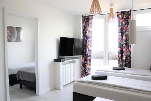 um quarto com 2 camas e uma televisão de ecrã plano em Labo Apartment Graniczna em Varsóvia