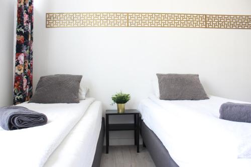 two beds sitting next to each other in a room at Labo Apartment Graniczna in Warsaw