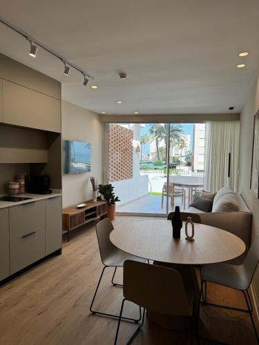 a kitchen and a living room with a table and chairs at Reyes Católicos Premium Beach, Playa Urbanova, Alicante in Alicante