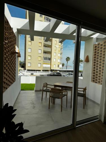 a patio with a table and chairs on a balcony at Reyes Católicos Premium Beach, Playa Urbanova, Alicante in Alicante