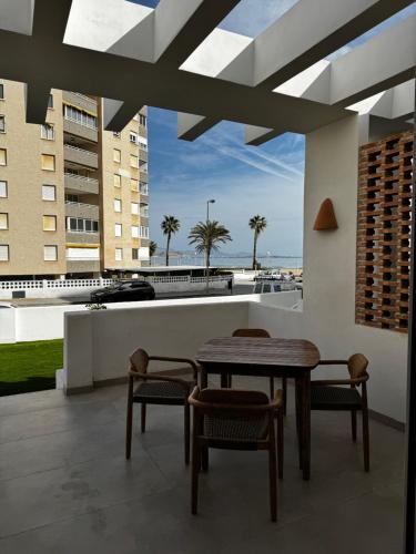 a table and chairs on a balcony with a view of the ocean at Reyes Católicos Premium Beach, Playa Urbanova, Alicante in Alicante