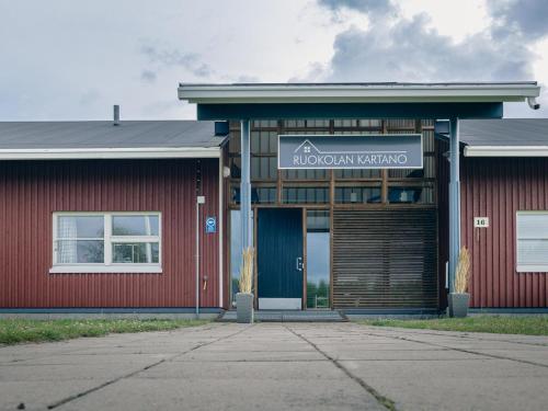 ein rotes Gebäude mit einem Schild, das Weisheitsmittel liest in der Unterkunft Holiday Home Ruokolan kartano by Interhome in Sotkamo