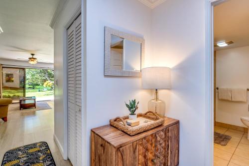 a hallway with a table with a lamp and a mirror at Koa Resort 1b in Kihei