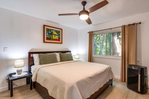 een slaapkamer met een bed, een plafondventilator en een raam bij Koa Resort 1b in Kihei
