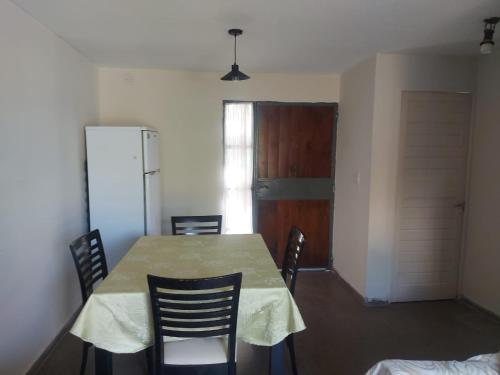 uma sala de jantar com uma mesa e cadeiras e uma porta em Doslilas em Guaymallén