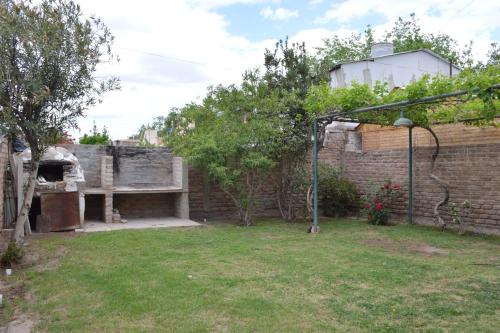 um quintal com uma parede de tijolos e um banco em Doslilas em Guaymallén