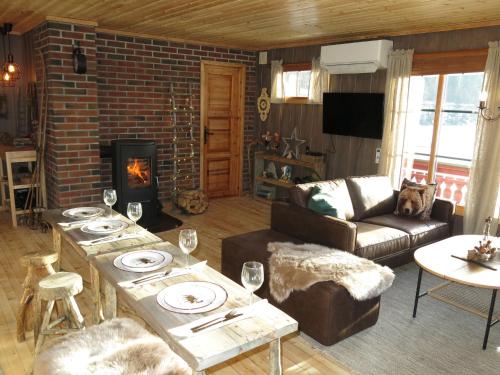 ein Wohnzimmer mit einem Tisch und einem Kamin in der Unterkunft Holiday Home Staksholmen - SOW725 by Interhome in Konsmo