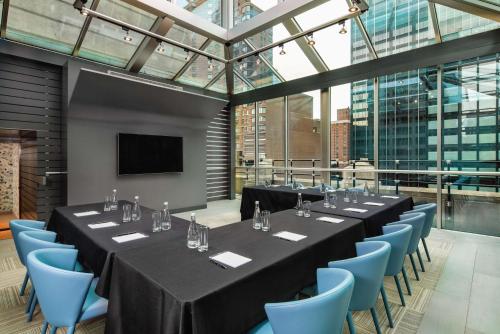 une salle de conférence avec des tables et des chaises bleues dans l'établissement The Time New York, part of JdV by Hyatt, à New York